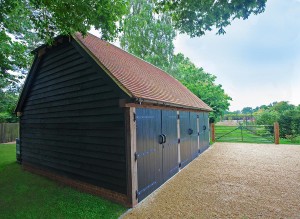 The black cladding and black Iroko doors on this three-bay oak building was a requirement of the Planning permission to tie-in with other out-buildings on the property.